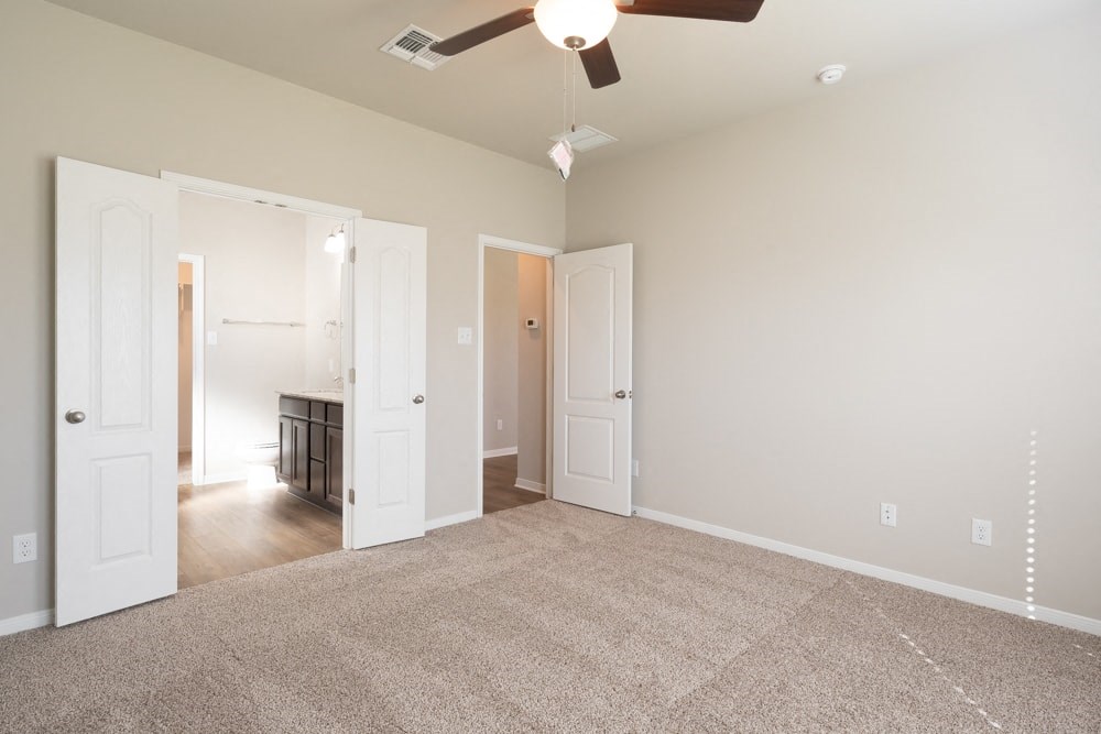 a living room with carpet and a ceiling fan