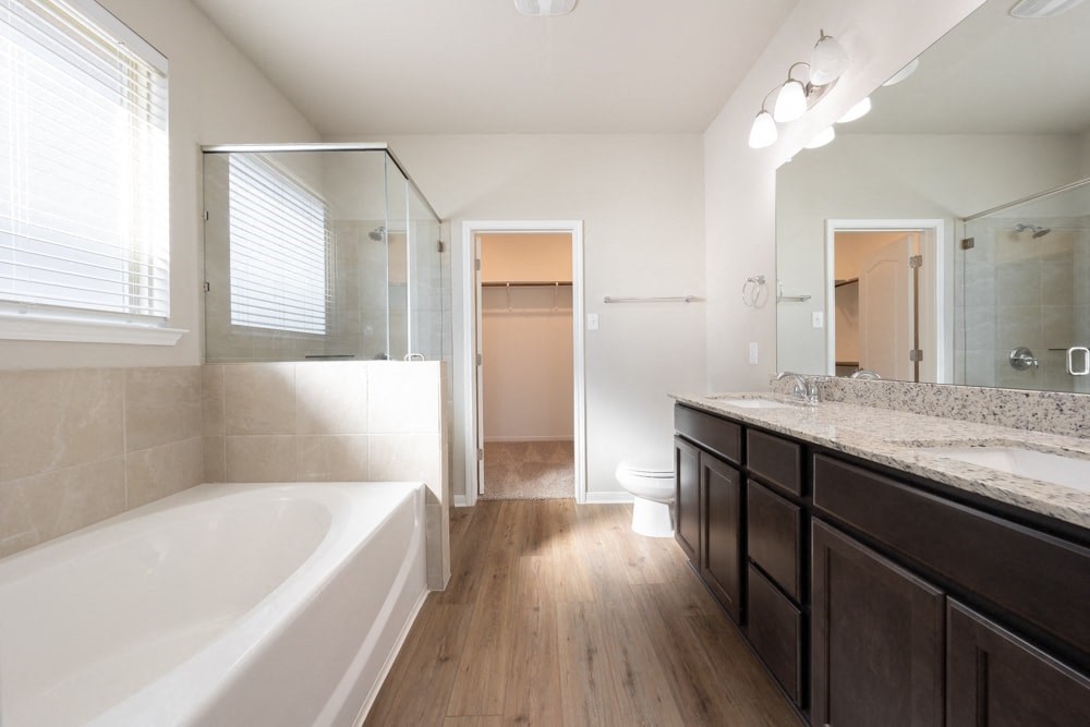 a bathroom with a large tub and a shower and a sink
