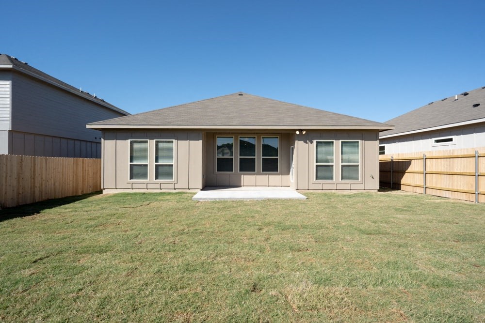 a backyard with a house and a fenced in yard