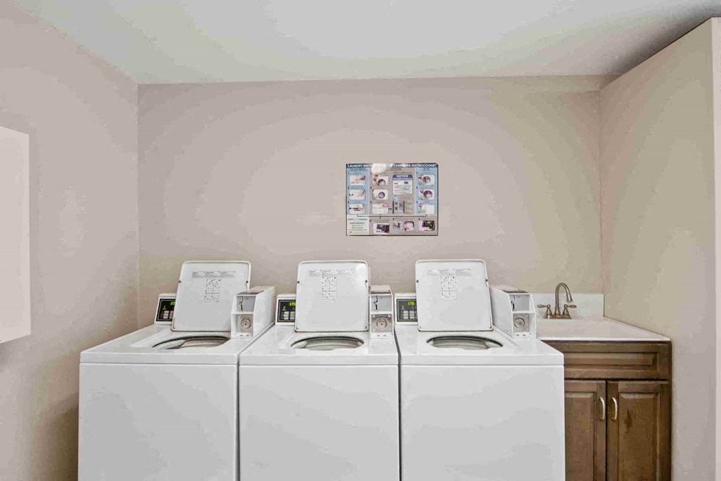 a laundry room with four washer and dryers in it