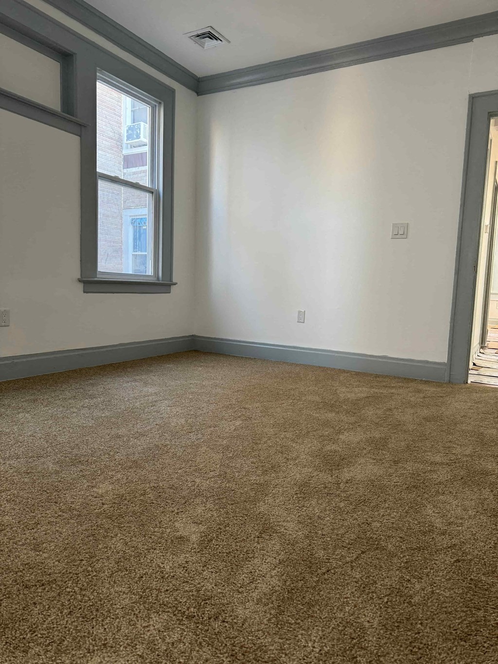 an empty room with carpet and a window