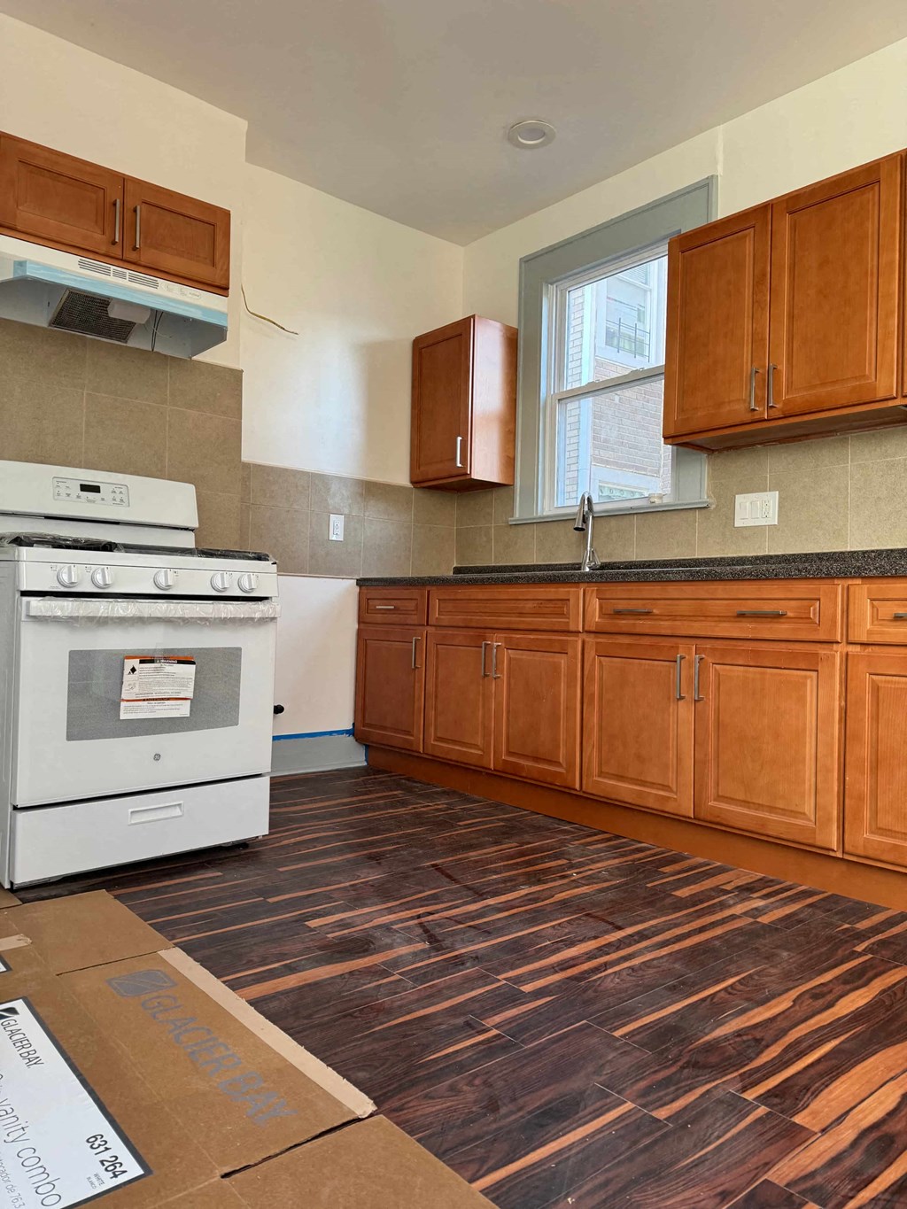 a kitchen with a stove top oven and wooden cabinets