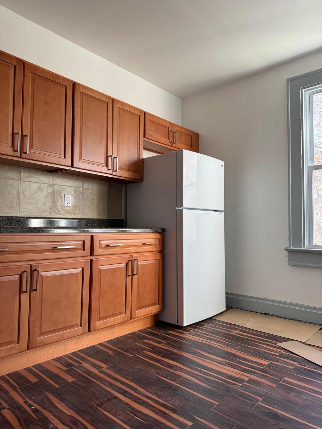 a kitchen with wooden cabinets and a white refrigerator