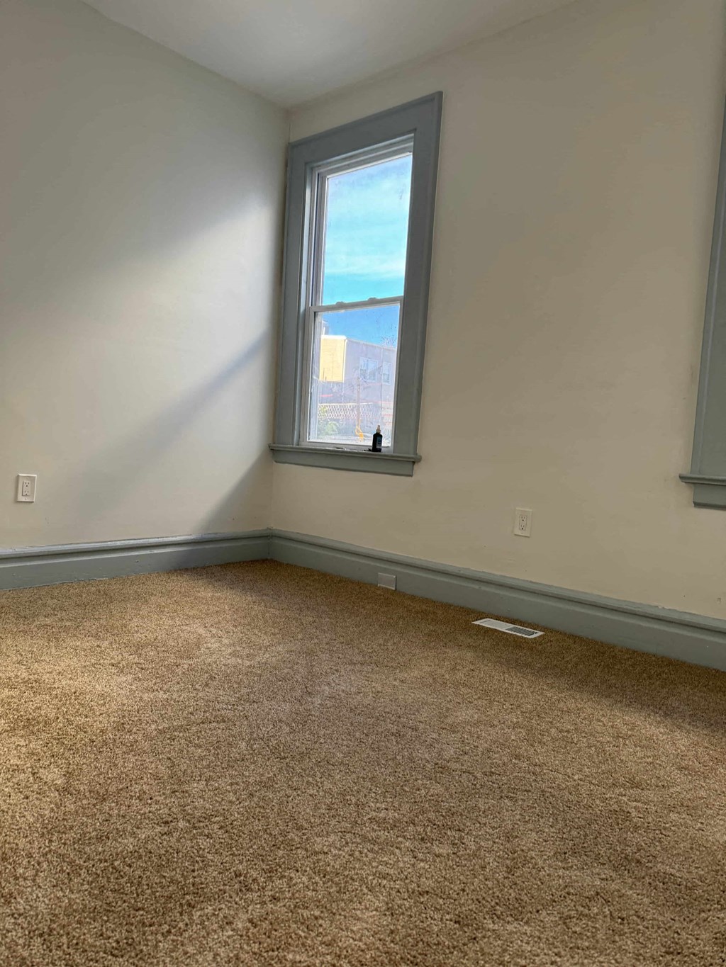 a room with a window and a carpet