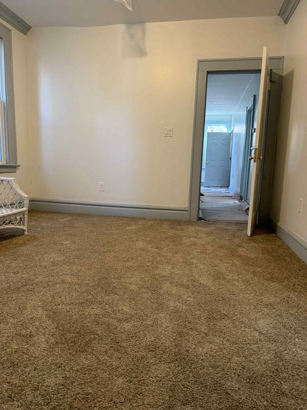 a room with a carpeted floor and a door to a bathroom