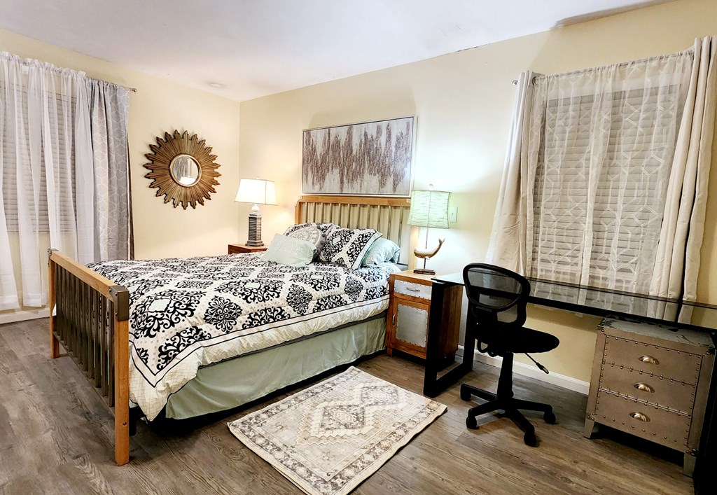 a bedroom with a bed and a desk with a chair