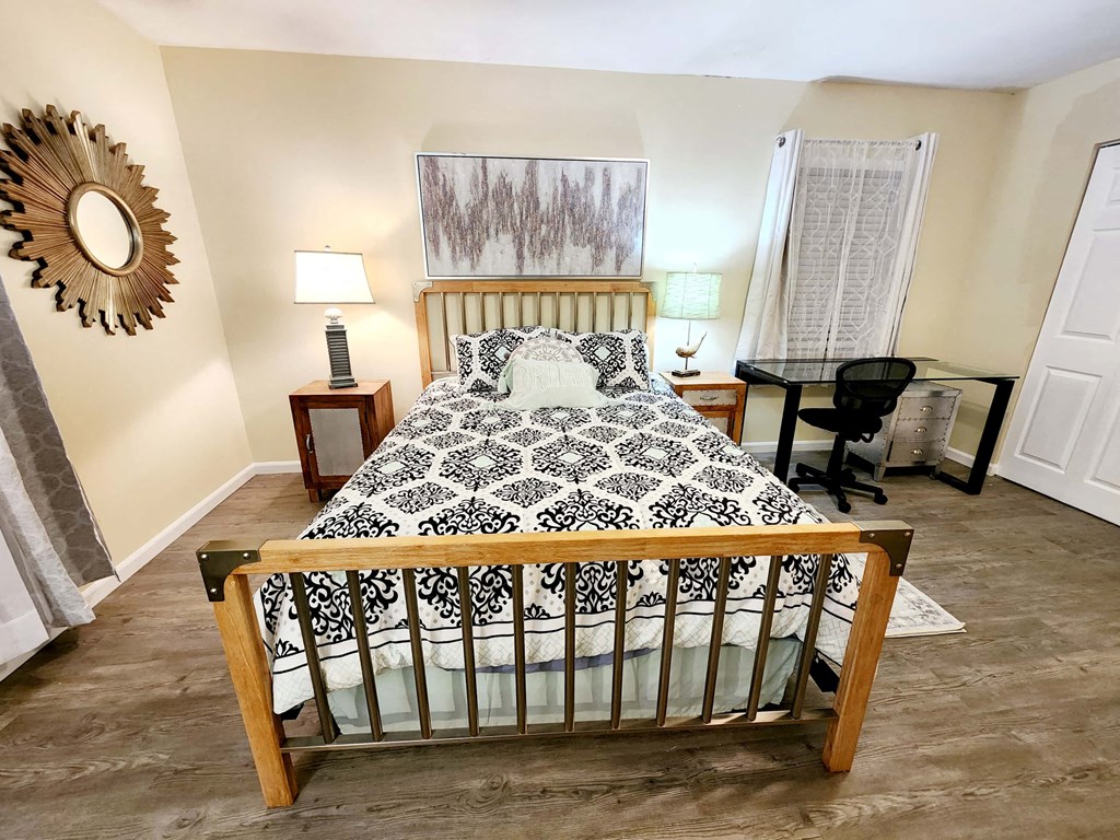 a bedroom with a bed and a desk and a window