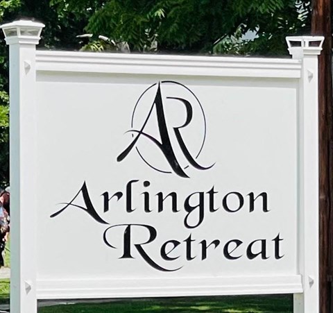 a white sign with the logo of an infinity retreat
