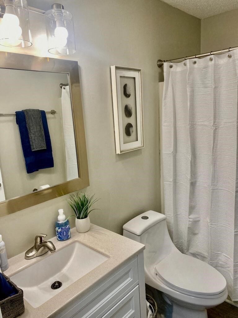 a bathroom with a sink toilet and a mirror
