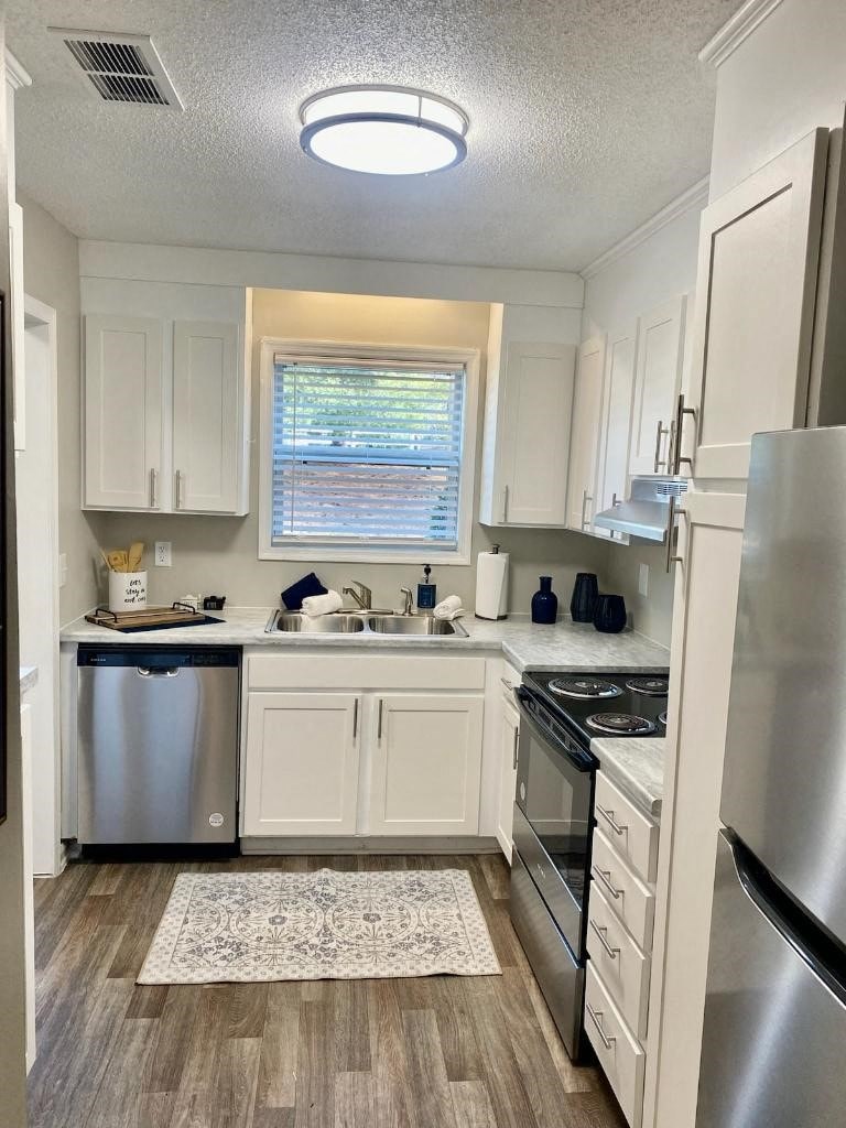 a small kitchen with white cabinets and stainless steel appliances