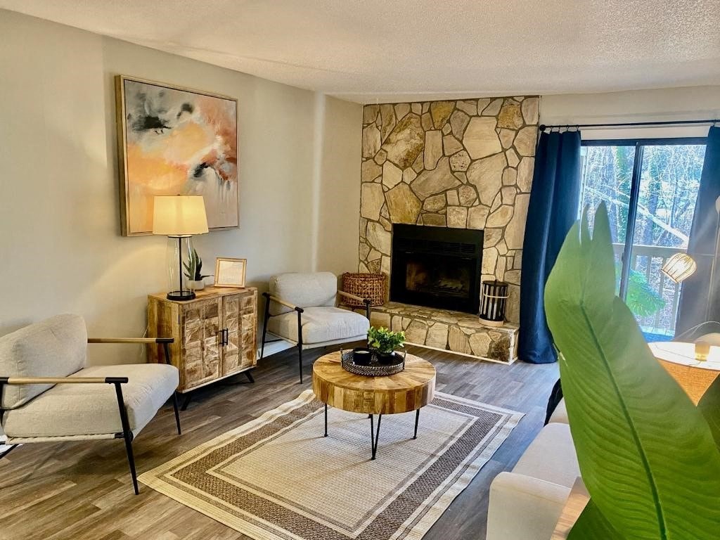 a living room with a stone fireplace and a large window