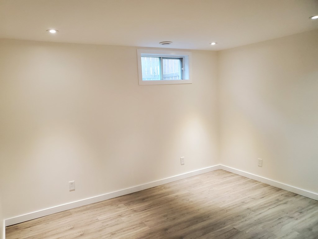 an empty room with wooden floors and a window