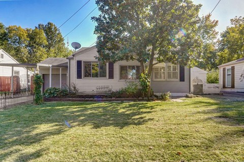 a white house with a yard and a tree