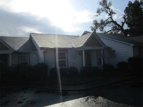 a white house with a sun shining on the roof