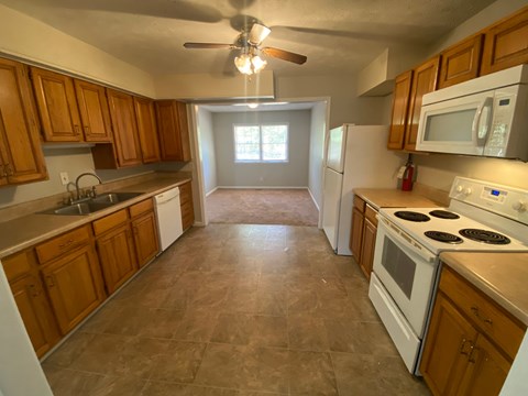 a kitchen with white appliances and wooden cabinets