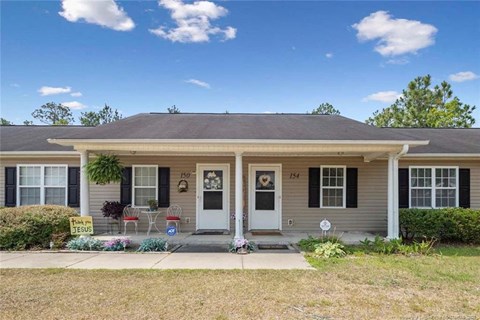 A house with a white door and a sign that says "For Sale".