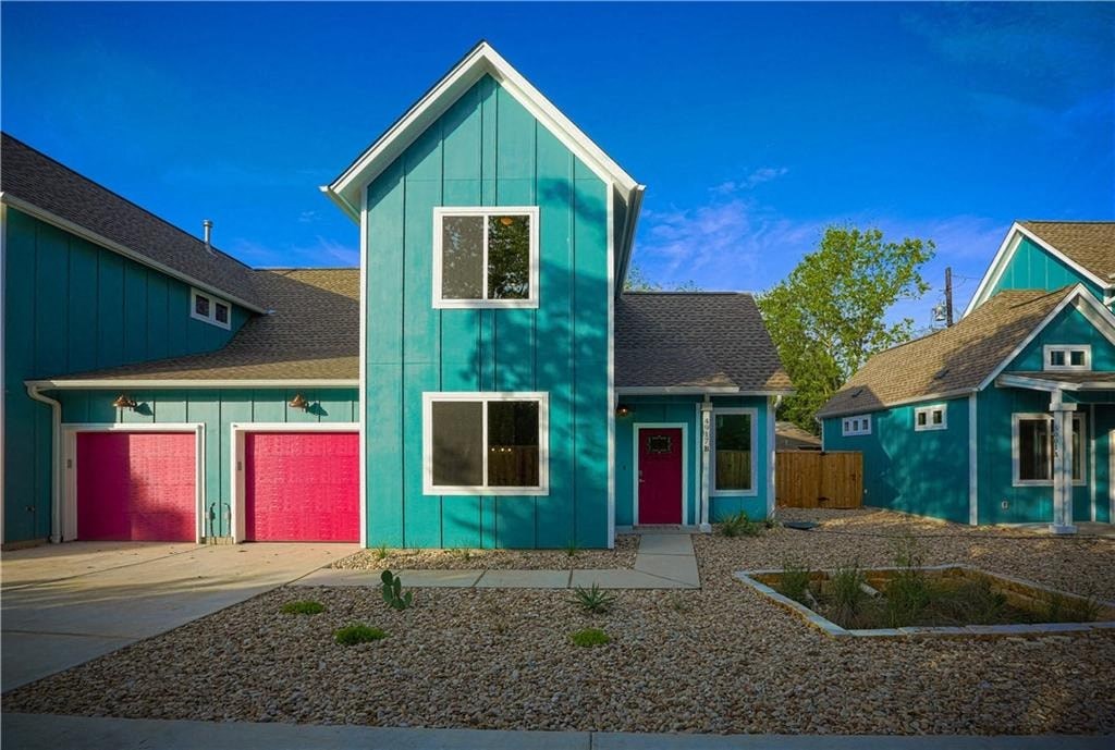 a blue house with a red garage door and a blue and green house