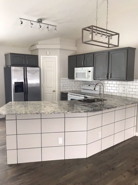 A kitchen with a white counter top and black cabinets.