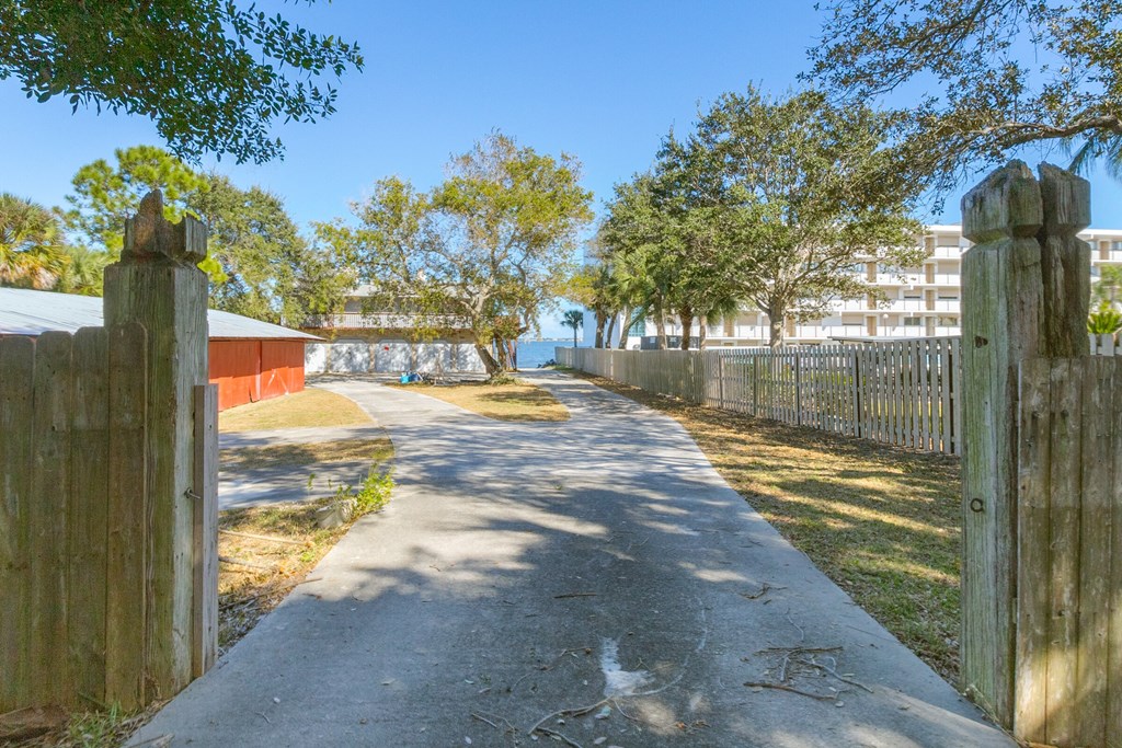 a sidewalk with a fence and trees on the side of a building