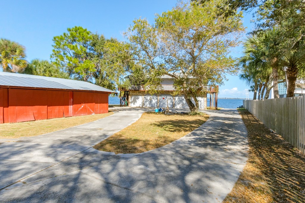 a path leading to a red building next to the water