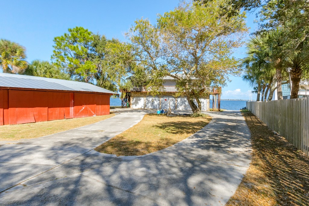 a path leading to a red building next to the water