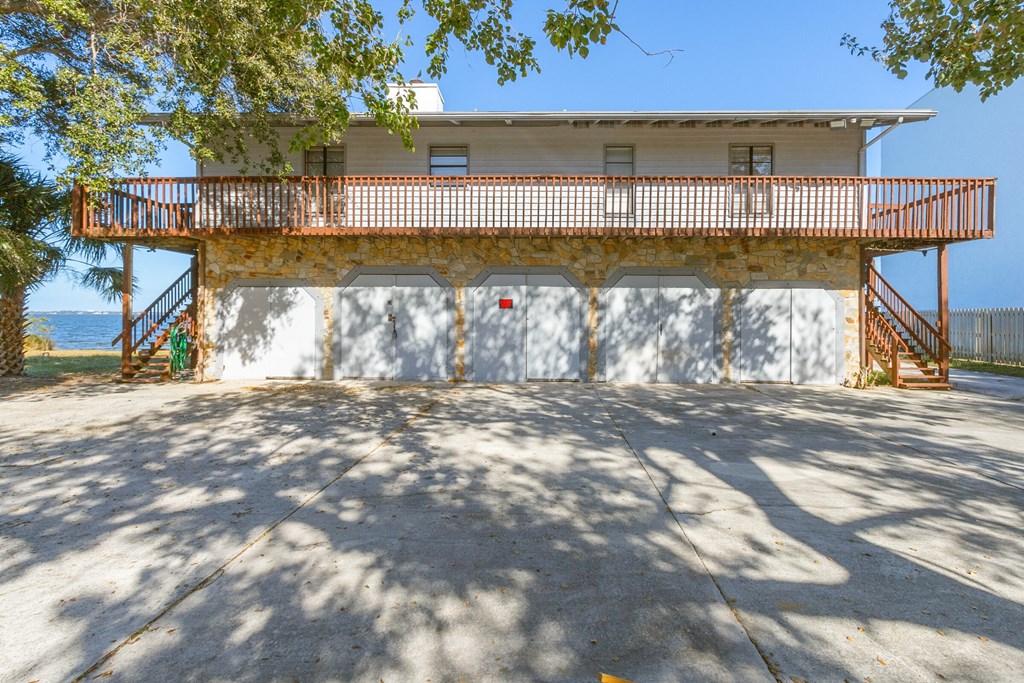the front of a house with a garage door and a balcony