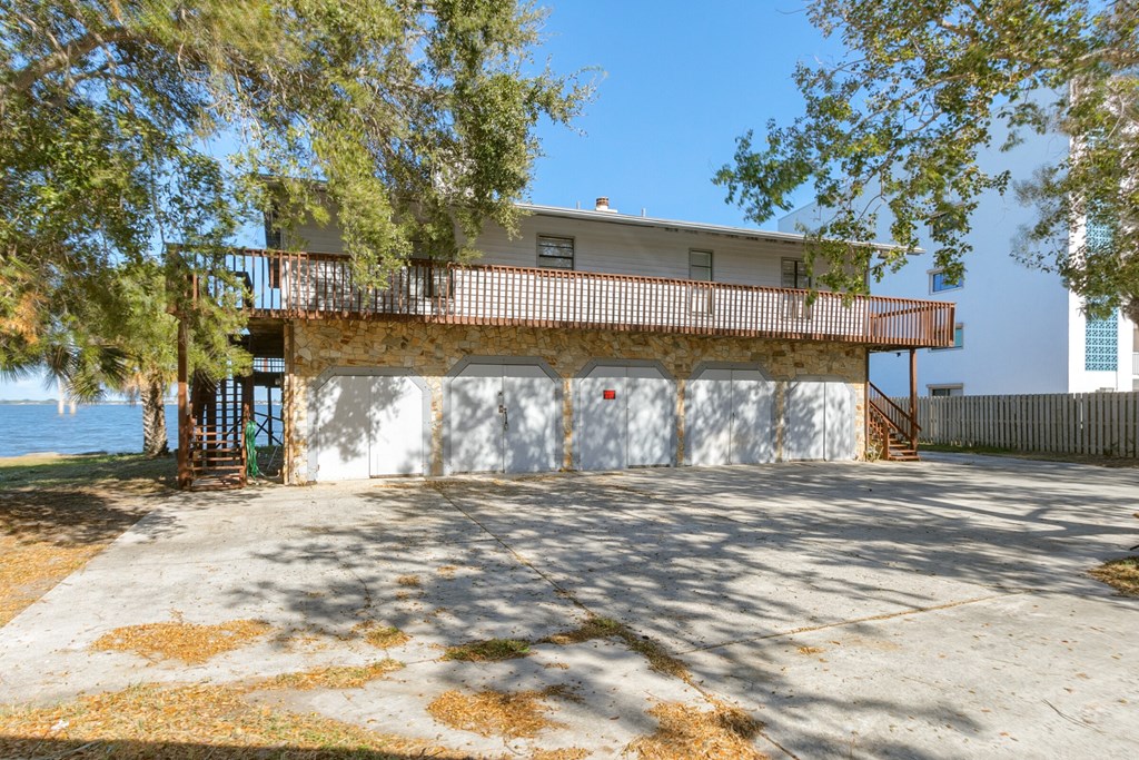 a garage with a balcony on top of it next to the water