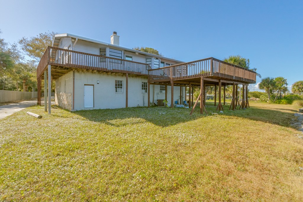 the back of a house with a deck and a yard