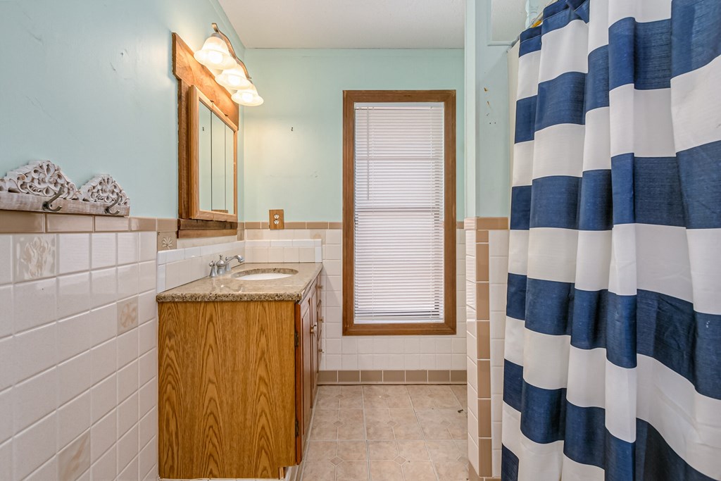 a bathroom with a blue and white shower curtain and a sink