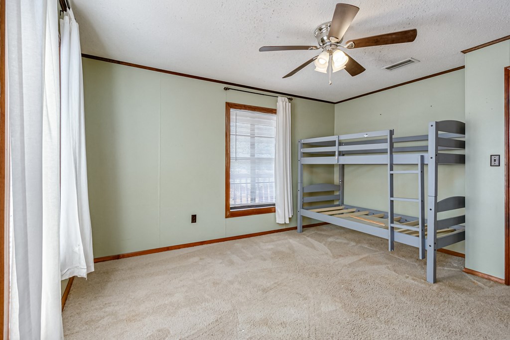 a bedroom with bunk beds and a ceiling fan