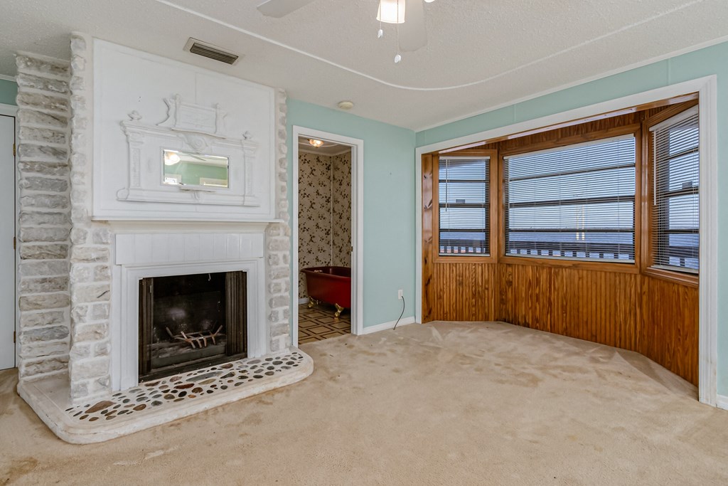 an empty living room with a fireplace and a window