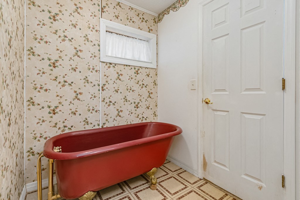 a bathroom with a red bath tub and a white door