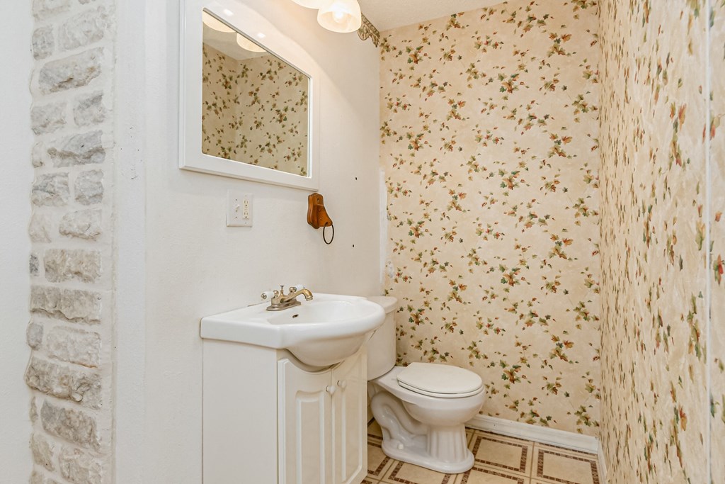 a bathroom with a toilet and a sink and a mirror