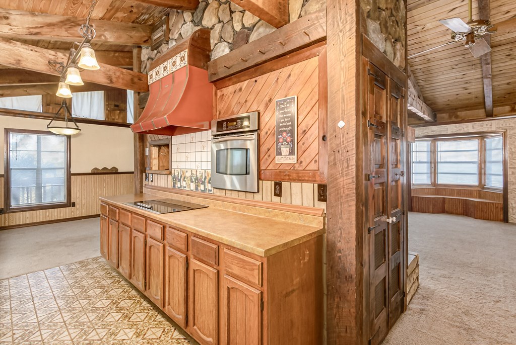 the kitchen has a large center island and wood cabinets