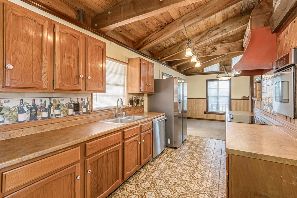 the kitchen is equipped with stainless steel appliances and wooden cabinets