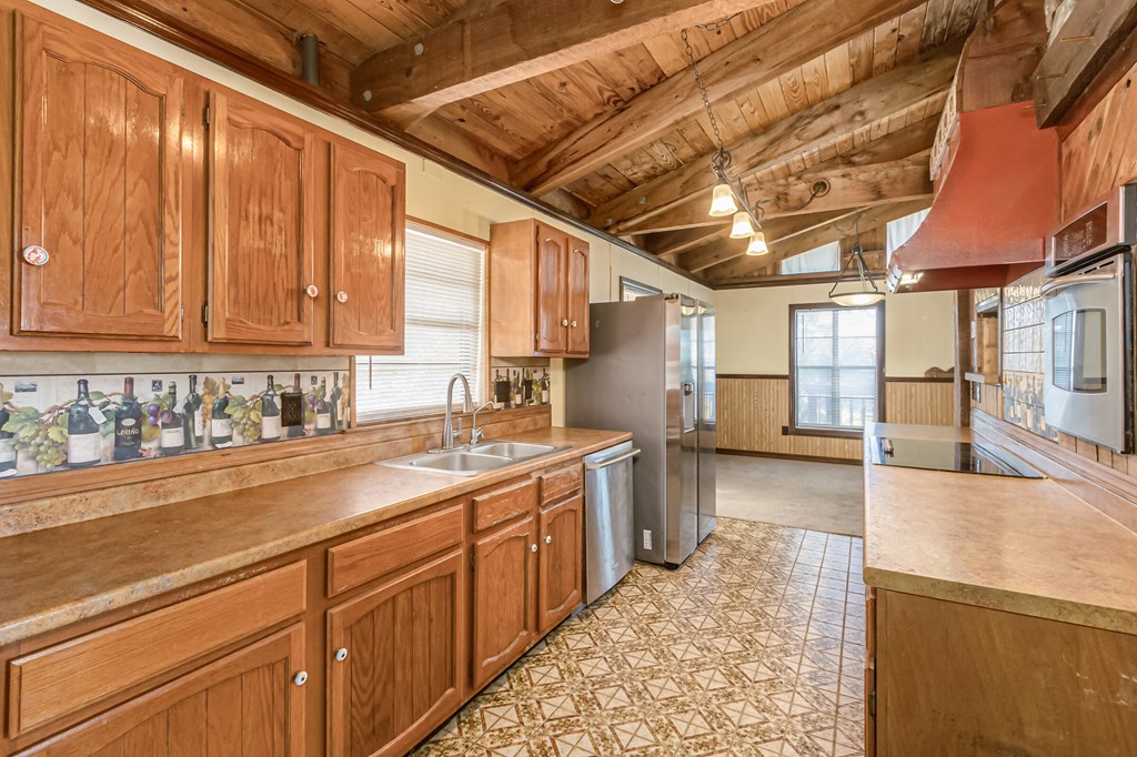 the kitchen is equipped with stainless steel appliances and wooden cabinets
