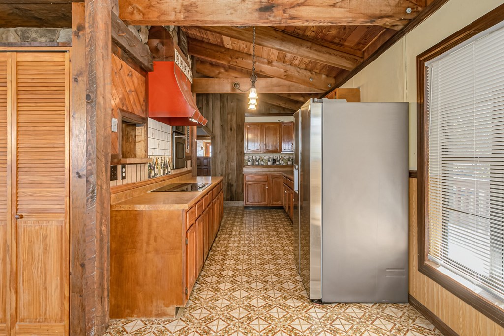 a kitchen with a stainless steel refrigerator and wooden cabinets