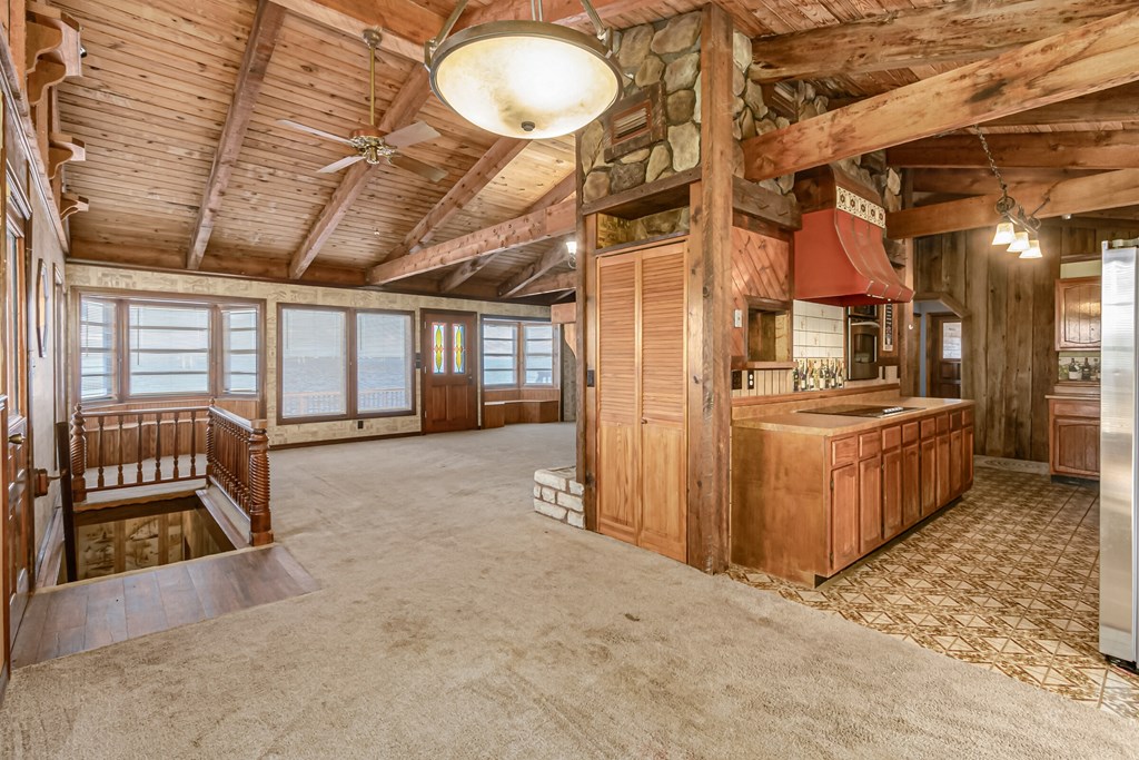 a large living room with a kitchen and a staircase
