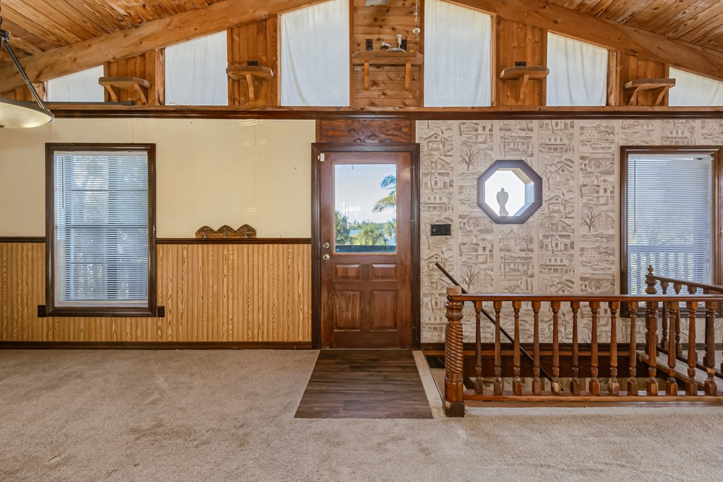 the entryway of a house with a staircase and a wooden door