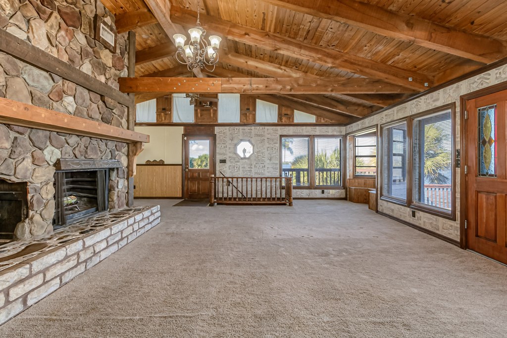 a large living room with a stone fireplace and a large window