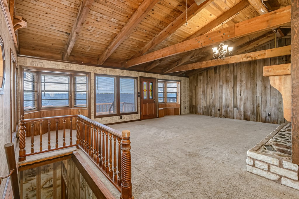 an empty living room with a balcony and a view of the ocean