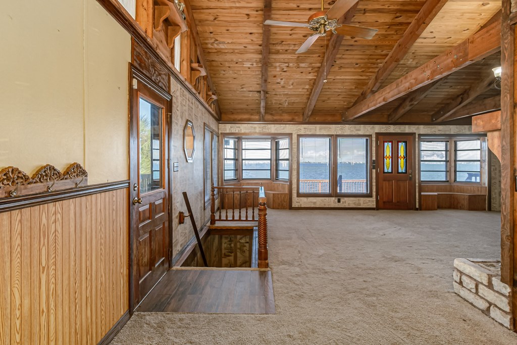 an open living room with wood paneling and a view of the ocean