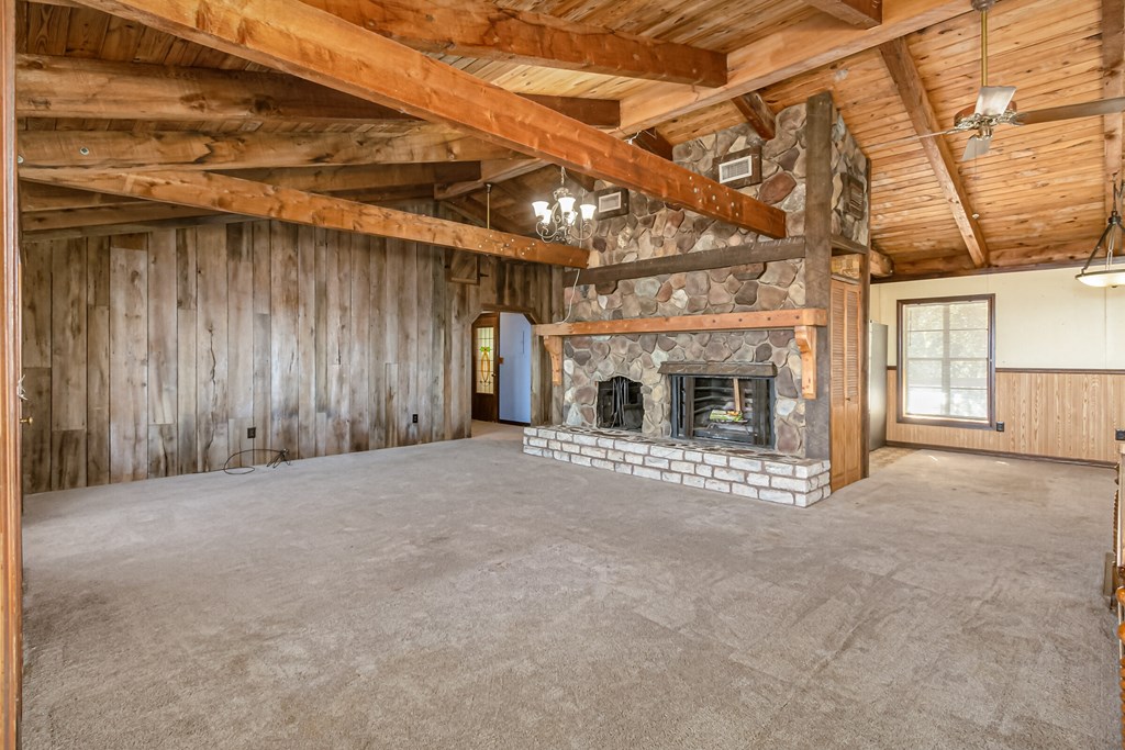 the living room of a cabin with a large stone fireplace