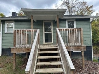 A small house with a porch and stairs leading to the front door.