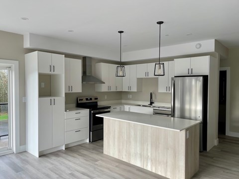 A modern kitchen with a large island and stainless steel appliances.