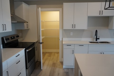 A kitchen with white cabinets and a black stove top oven.