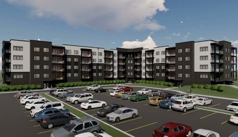 A parking lot with cars and apartment buildings in the background.