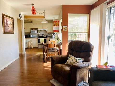 a living room with a couch and a chair and a kitchen