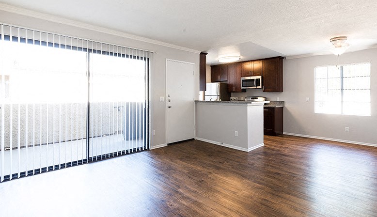 an empty living room and kitchen with a large window