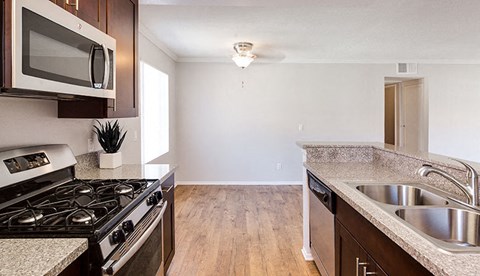 an empty kitchen with a stove and a sink